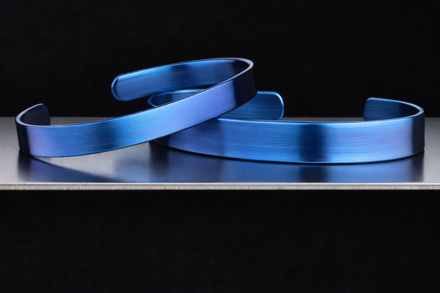 Two hand-scraped titanium cuffs with anodized colour finish
